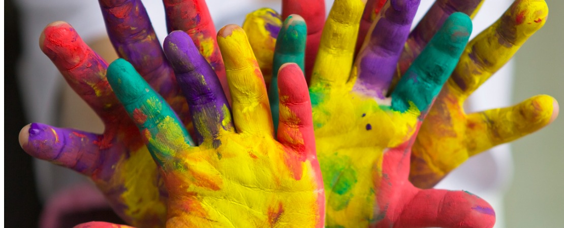 Crianças com as mãos sujas de tinta com as cores em inglês