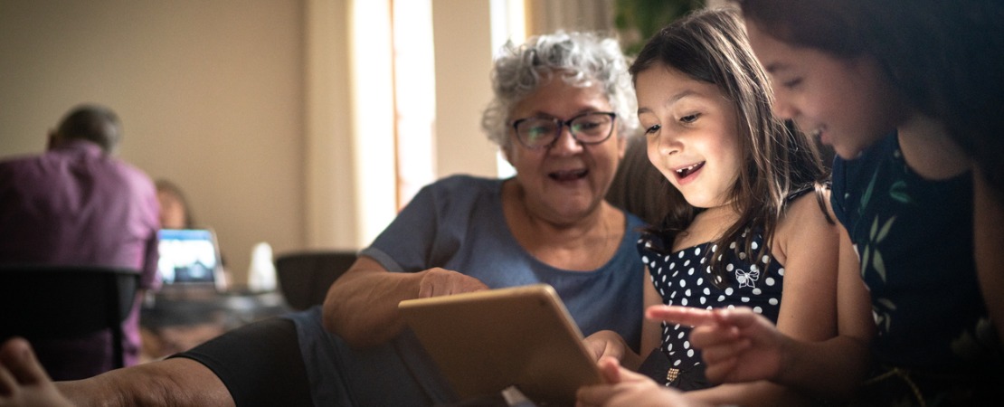 Avó lendo um texto infantil em inglês com suas netas