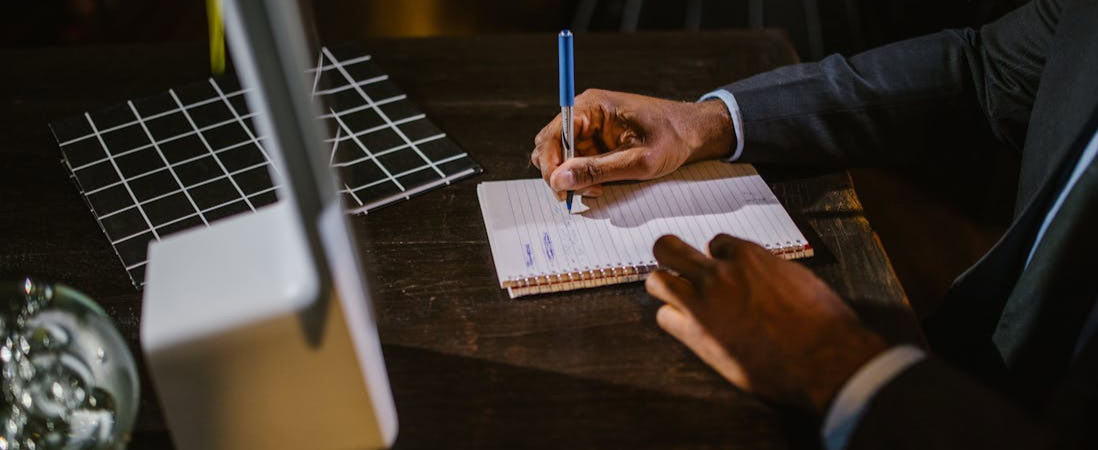 Imagem mostrando uma pessoa fazendo anotações, representando os melhores cursos de inglês para adultos.