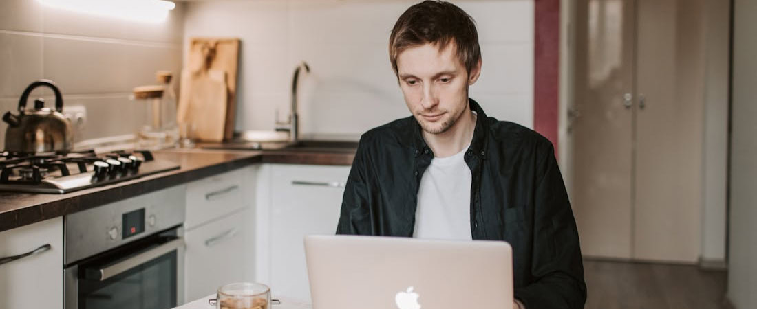 Imagem mostrando um rapaz estudando com um laptop, representando o melhor curso de inglês online.