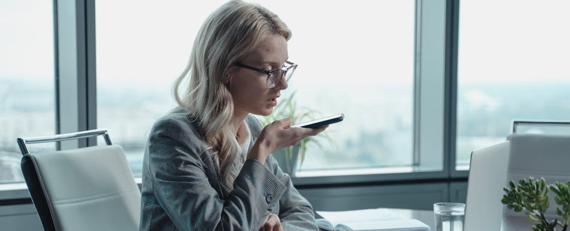 Imagem mostrando uma mulher usando um celular, representando um app para aprender inglês online.