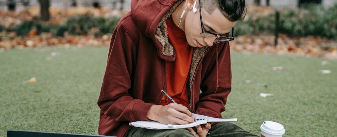 Imagem mostrando uma pessoa estudando com um caderno e um laptop, representando as aulas de inglês ao vivo.