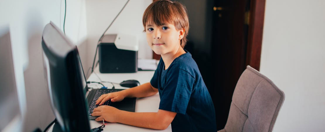 Imagem mostrando uma criança estudando em frente a um computador, representando o melhor curso de inglês online para crianças.