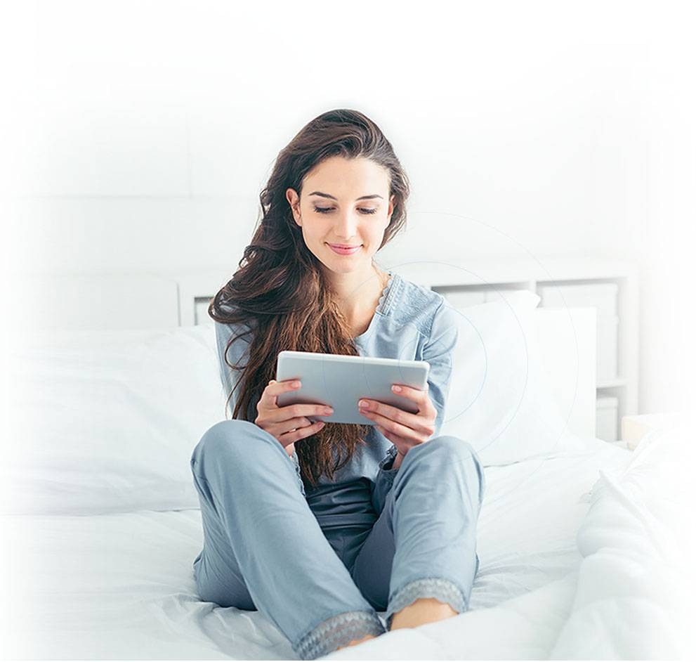user with tablet on the bed